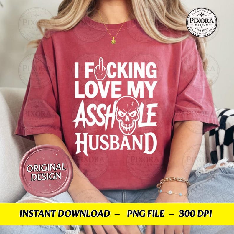 May include: A red short-sleeved t-shirt featuring white text that reads I FOCKING LOVE MY ASSHOLE HUSBAND, with a graphic of a middle finger replacing the letter O in FOCKING and a skull illustration replacing the letter O in ASSHOLE.