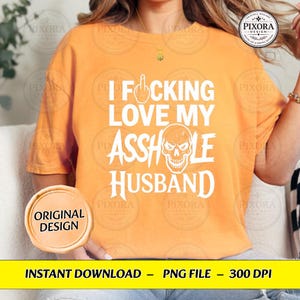 May include: An orange short-sleeved t-shirt featuring white text that reads I FOCKING LOVE MY ASSHOLE HUSBAND, with a graphic of a middle finger replacing the letter O and a skull illustration replacing the letter O in the word ASSHOLE.
