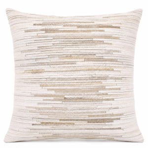 May include: A square throw pillow featuring a horizontal striped pattern composed of thin, layered strips in varying shades of cream, beige, and light tan. The surface texture is created by the overlapping arrangement of these narrow, linear segments.