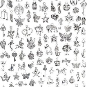 May include: A large collection of assorted silver-toned metal charms featuring various shapes including animals, keys, hearts, stars, butterflies, trees, musical notes, religious symbols, and mythical creatures, each with a small loop for attachment.