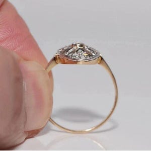 Peut inclure: Une bague en or dot&eacute;e d'une t&ecirc;te de forme ovale avec une surface sup&eacute;rieure argent&eacute;e sertie de multiples petites pierres claires &agrave; facettes. L'anneau est fin et circulaire, fabriqu&eacute; en or jaune poli, reli&eacute; au sertissage orn&eacute; de pierres.