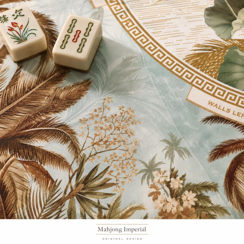 May include: Two off-white mahjong tiles with green and red markings resting on a light blue fabric featuring a brown palm tree and floral print with a gold geometric border and the text WALLS LEFT and Mahjong Imperial Original Design.