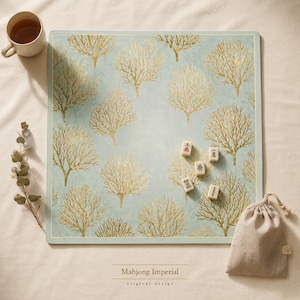 May include: A square light blue game mat featuring a repeating pattern of gold-colored coral-like tree silhouettes. Five small rectangular mahjong tiles with black and red characters are placed on the mat, accompanied by a beige drawstring storage bag.
