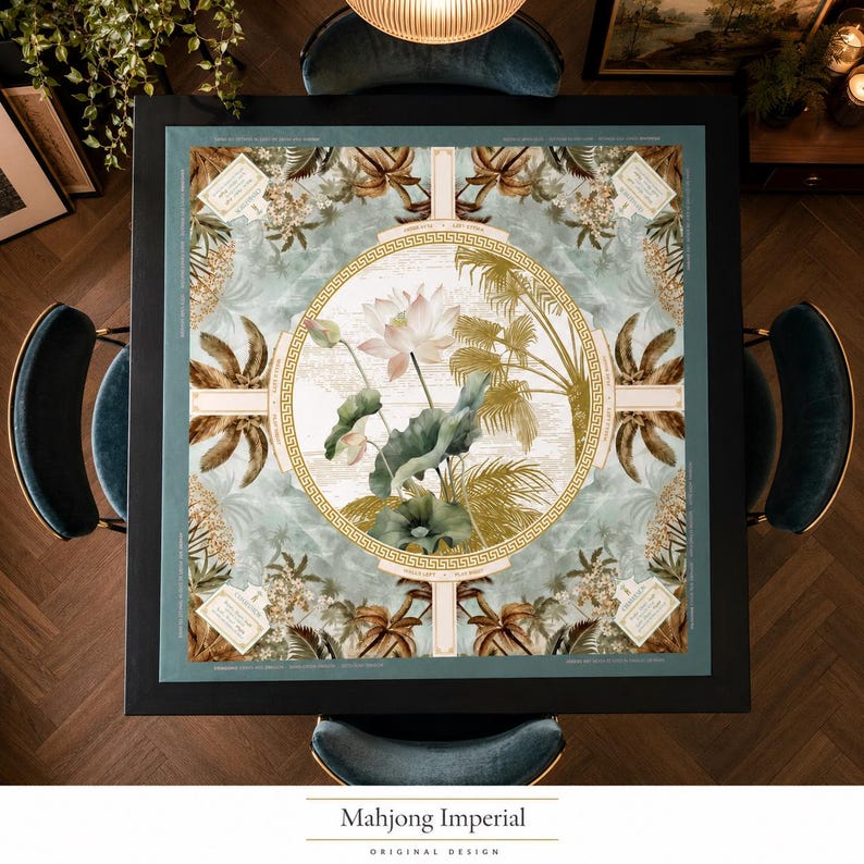 May include: A square table mat featuring a central circular medallion with a lotus flower and palm leaves, surrounded by a Greek key border. The background displays a tropical botanical pattern in shades of sage green, gold, and cream.