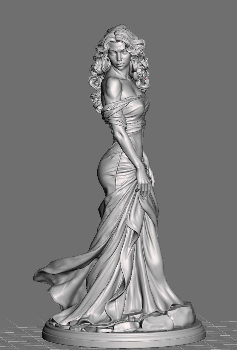 Puede incluir: Un modelo digital 3D gris de una figura de pie con cabello largo y ondulado, que viste un vestido con hombros descubiertos y tela drapeada que se acumula en la base. La figura est&aacute; colocada sobre una plataforma circular con detalles rocosos.