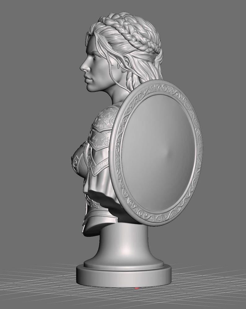 May include: A grey 3D digital model of a bust featuring a person with braided hair, wearing ornate armor and holding a large circular shield with an intricate border pattern. The sculpture is mounted on a simple pedestal base against a plain background.