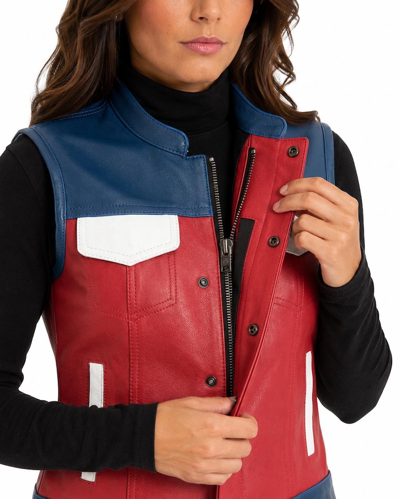 Puede incluir: Un chaleco sin mangas de cuero en colores rojo, azul y blanco. La prenda presenta un panel superior azul en el pecho, un cuerpo principal rojo y solapas de bolsillo blancas. Incluye un cierre de cremallera central con una tapeta de botones a presi&oacute;n.