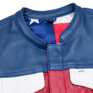 Puede incluir: Una chaqueta de cuero azul, roja y blanca con cuello mao y cierre frontal. El forro interior muestra un patr&oacute;n estampado de una estrella blanca sobre un campo azul junto a rayas rojas y blancas, visible en la l&iacute;nea del cuello.