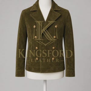 Puede incluir: Una chaqueta cruzada de ante verde oliva con solapa de muesca ancha, mangas largas y seis botones metálicos dorados dispuestos en dos filas verticales. El texto KINGSFORD LEATHER está impreso en dorado en el centro de la chaqueta.