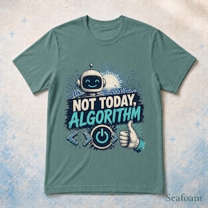 May include: A sage green short-sleeve t-shirt featuring a graphic of a smiling robot head, a power button icon, and a hand giving a thumbs-up. The text reads "NOT TODAY, ALGORITHM" in bold white and light blue lettering with circuit board patterns.