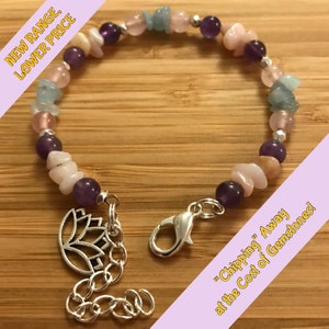 May include: A bracelet made with amethyst, rose quartz, and aquamarine gemstones. The bracelet has a silver clasp and a silver lotus charm. The bracelet is on a wooden surface. "Chipping" Away at the Cost of Gemstones! is written on a pink and yellow banner.