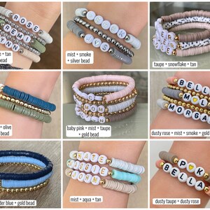May include: A set of colorful beaded bracelets with personalized names, including "Rose Remy Elynn", "Derek Jys", "Er Ear Ole", "Bella Mol Morgan", "Onate Waggie John", and "Bella Gpk". The bracelets are made with different colors of beads, including pink, blue, green, and brown.