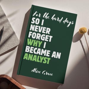May include: A dark green hardcover journal featuring white and light green text that reads: For the hard days SO I NEVER FORGET WHY I BECAME AN ANALYST Alice Grace. The book cover has a clean, matte finish with bold, sans-serif typography.