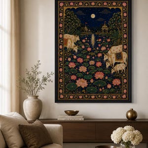 May include: A rectangular wall art print in a black frame featuring a dark blue night scene with a full moon, a pond filled with pink lotus flowers, and white cows drinking water. The artwork is bordered by a decorative gold and floral pattern.
