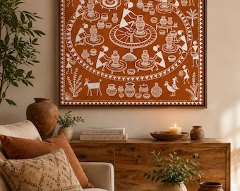 Może przedstawiać: Kwadratowa dekoracja ścienna z białymi ilustracjami w stylu ludowym Warli na tle w kolorze terakoty. Dzieło przedstawia kolistą scenę postaci zajmujących się wyrobem ceramiki, otoczoną chatami, drzewami, zwierzętami i geometrycznymi obramowaniami.