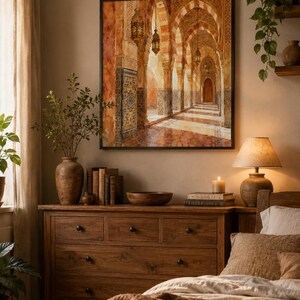 May include: A square wall art print featuring an architectural perspective of a corridor with arched stone columns, intricate tile patterns, and hanging lanterns. The artwork displays warm orange, brown, and gold tones, depicting a sunlit hallway.