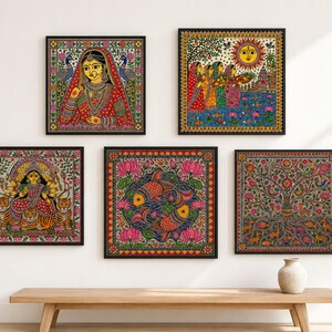 May include: A set of five square framed wall art pieces featuring vibrant Madhubani style paintings. The collection includes depictions of a woman in traditional attire, figures by a river, a multi-armed deity with tigers, two fish, and a tree.
