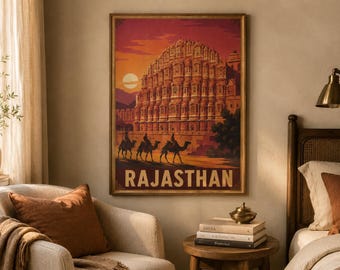 Może przedstawiać: Prostokątny wydruk ścienny przedstawiający stylizowaną ilustrację Hawa Mahal w Radżastanie w Indiach. Grafika utrzymana jest w ciepłej kolorystyce zachodzącego słońca z odcieniami pomarańczu i czerwieni, z trzema wielbłądami oraz napisem RAJASTHAN.