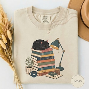 Maglietta con gatto nero che sonnecchia sui libri, regalo carino per amanti dei gatti e dei libri, maglietta accogliente con gatto che legge, maglietta per mamme di gatti in biblioteca, regalo carino per amanti dei gattini