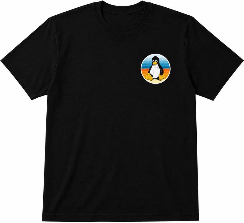 以下が含まれることがあります： 左胸に円形のグラフィックが施された黒の半袖Tシャツ。グラフィックには、黄色い足とくちばしを持つ白黒のペンギンが描かれており、背景には青、オレンジ、黄色の水平なストライプがデザインされています。