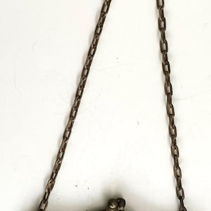Peut inclure: Un sac &agrave; main ancien en m&eacute;tal argent&eacute; avec une cha&icirc;ne. Le sac pr&eacute;sente un cadre d&eacute;coratif avec des d&eacute;tails floraux et une fermeture &agrave; fermoir. Le motif en r&eacute;sille comprend des couleurs noires, vertes et oranges.