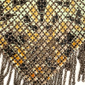 Peut inclure: Gros plan sur un sac &agrave; main vintage en m&eacute;tal maill&eacute; avec un motif g&eacute;om&eacute;trique dans les tons de vert, jaune, noir et argent. Le sac &agrave; main pr&eacute;sente une frange de cha&icirc;nes m&eacute;talliques pendantes sur le bord inf&eacute;rieur.