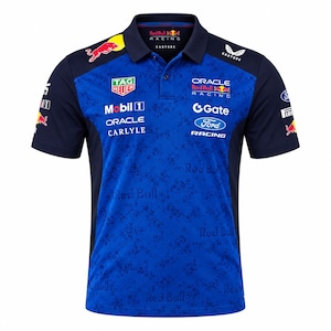 May include: A blue polo shirt featuring a dark blue collar and side panels. The front displays various sponsor logos including Oracle Red Bull Racing, Tag Heuer, Mobil 1, Carlyle, Gate, and Ford. A subtle Red Bull text pattern covers the blue fabric.