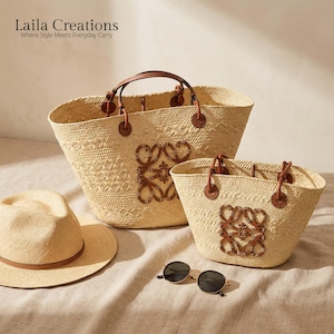 Può includere: Due borse tote in paglia intrecciata con manici in pelle marrone e una toppa con logo centrale in pelle marrone, un cappello fedora in paglia con fascia in pelle marrone e occhiali da sole rotondi neri. Testo: Laila Creations Where Style Meets Everyday Carry.