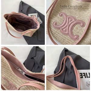 K&ouml;nnte beinhalten: Eine beige geflochtene Strohtasche mit rosafarbenen Bes&auml;tzen und Griffen in Lederoptik. Die Vorderseite zeigt ein gro&szlig;es, gepr&auml;gtes rosafarbenes Emblem. Das Innere ist mit dunklem Stoff ausgekleidet und hat einen Rei&szlig;verschluss mit silbernem Metallschieber.