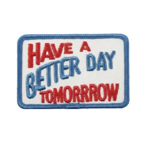 May include: A rectangular embroidered patch with a white background and a blue border. The text reads HAVE A in red, BETTER DAY in blue, and TOMORRROW in red. The patch features a misspelling of the word tomorrow with an extra R.