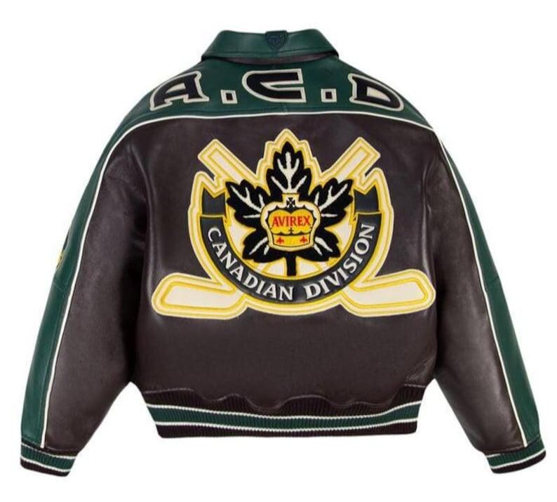 May include: A dark brown and green leather varsity jacket featuring a large embroidered patch on the back. The patch displays a black maple leaf, two crossed hockey sticks, a yellow crown with the text AVIREX, and CANADIAN DIVISION text.
