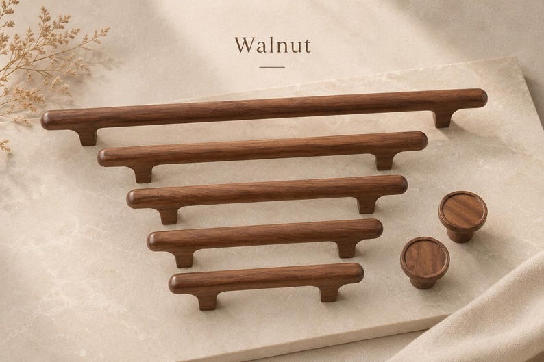 Puede incluir: Una colecci&oacute;n de herrajes para armarios de madera de nogal marr&oacute;n oscuro, que incluye cinco tiradores de barra horizontales de distintas longitudes y dos pomos circulares. La palabra Walnut aparece impresa sobre los herrajes de acabado liso.