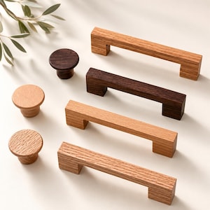 May include: A collection of wooden cabinet hardware including three rectangular drawer pulls and three circular knobs. The items feature various wood tones ranging from light oak to dark walnut, showcasing natural grain patterns and smooth finishes.