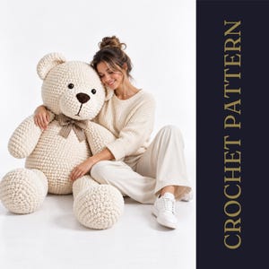 Może przedstawiać: Duży, kremowy szydełkowany miś z ciemnobrązowym nosem i brązowo-białą kokardą w kratkę na szyi. Napis CROCHET PATTERN jest wyświetlany pionowo złotymi literami na ciemnoniebieskim tle.