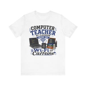 May include: A white t-shirt featuring a graphic with the text "COMPUTER TEACHER MY CLASSROOM RUNS ON WI-FI and CAFFEINE". The design includes a laptop, a mug labeled "Fueled by Caffeine", a small chalkboard, and a stack of books labeled with coding languages.