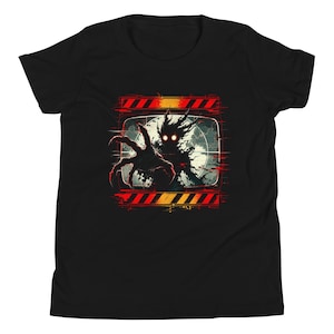 May include: A black short-sleeve t-shirt featuring a graphic print of a dark, shadowy creature with glowing red eyes reaching out from a vintage television screen. The design includes red and orange hazard stripes above and below the screen.