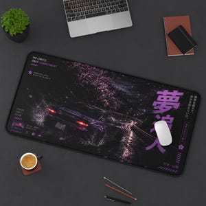 Könnte beinhalten: Eine rechteckige Schreibtischunterlage mit einer dunklen, atmosphärischen Szene eines Sportwagens, der nachts auf einer nassen Straße fährt. Das Design enthält violette Kirschblütenakzente, japanischen Text und die englischen Phrasen NO LIMITS.