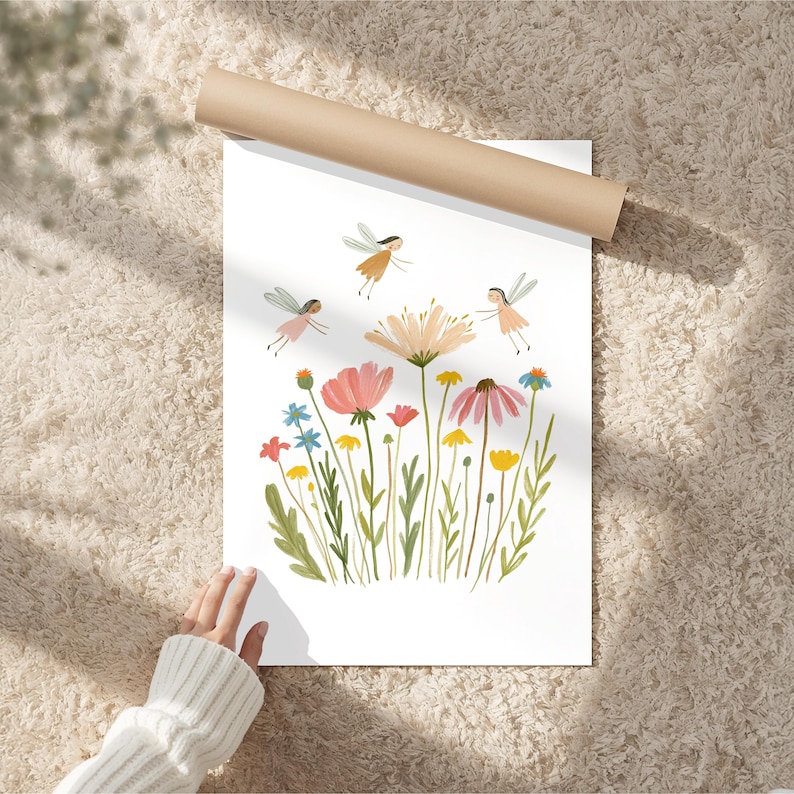 May include: A white art print featuring a colorful illustration of various wildflowers in shades of pink, yellow, blue, and green, accompanied by three small winged figures with brown hair flying above the stems on a clean white background.