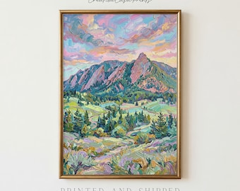 May include: A vertical framed wall art print featuring an impressionistic oil painting of a mountain landscape. The scene displays rugged peaks under a sky filled with pink, purple, and blue clouds, with green pine trees and rolling hills below.