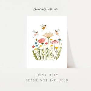 May include: A white art print featuring the text Creative Casa Prints at the top and Print Only Frame Not Included at the bottom. The center displays a colorful illustration of various wildflowers and three small winged figures in flight.