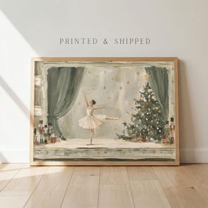 May include: A framed art print featuring a ballerina in a white tutu dancing on a stage with a Christmas tree, gold stars, and nutcracker figures. The scene includes dark green curtains and the text PRINTED & SHIPPED at the top of the frame.