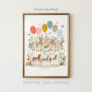 May include: A framed art print titled Creative Casa Prints featuring a carousel with three horses, colourful balloons, and floral arrangements. The illustration includes bunting flags, small birds, and a variety of wildflowers in shades of pink, yellow, and blue.