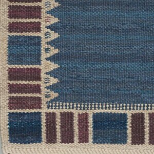 May include: A woven rug featuring a large solid blue central field bordered by a geometric pattern of alternating dark blue and deep maroon rectangular blocks separated by thin cream-colored lines and a jagged sawtooth edge.