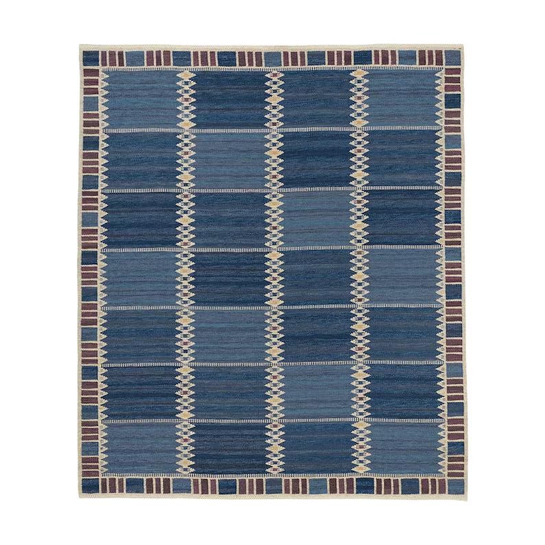 May include: A rectangular area rug featuring a grid of alternating dark and medium blue blocks. The design includes vertical columns of small, light-colored diamond patterns and a border composed of alternating dark blue and maroon rectangular segments.