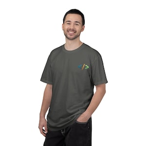 Peut inclure: Un t-shirt gris anthracite à manches courtes avec un petit symbole de crochet de code brodé sur la poitrine gauche. Le symbole se compose d'un crochet gauche bleu, d'une barre oblique dorée et d'un crochet droit vert, créant un motif coloré.