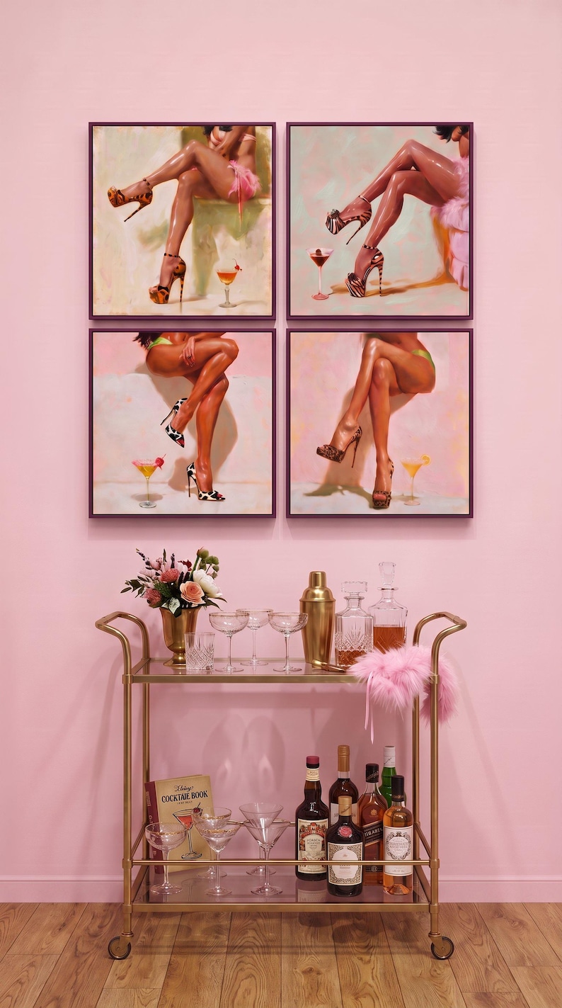 Cocktail wall art set of 4 in dark purple frames above a gold bar cart with martini glasses, a shaker and pink flowers on a pink wall