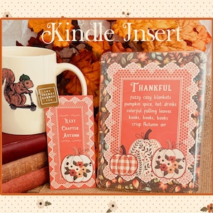 Könnte beinhalten: Ein Kindle-Einsatz, ein Lesezeichen und eine weiße Tasse mit Eichhörnchen-Motiv. Der Einsatz zeigt Kürbisse, Spitzenbordüren und den Text: Thankful, fuzzy cozy blankets, pumpkin spice, hot drinks, colorful falling leaves, books, books, books, crisp Autumn air.