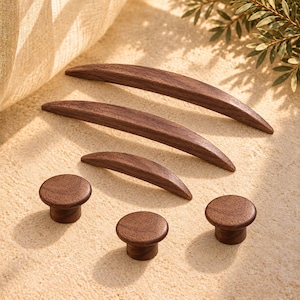 May include: A collection of dark brown wooden cabinet hardware consisting of three curved handles of varying lengths and three circular knobs. Each piece features a smooth, polished finish with visible wood grain patterns throughout the set.
