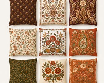 Op de afbeelding: Een collectie van negen vierkante sierkussens met diverse patronen, waaronder bloemmotieven, paisley-ontwerpen en botanische illustraties in tinten bruin, crème, oranje en groen. Elk kussen toont een eigen, gedetailleerde print.