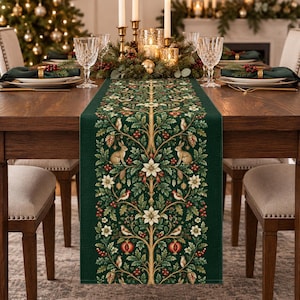 Peut inclure: Un chemin de table vert foncé orné d'un imprimé botanique symétrique représentant des lapins, des oiseaux, des fleurs de poinsettia blanches, des baies rouges et des pommes de pin. Le motif complexe est disposé le long d'une branche centrale.